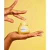 Glow Recipe Banana Soufflé Moisture Cream bottle in hands with yellow background
