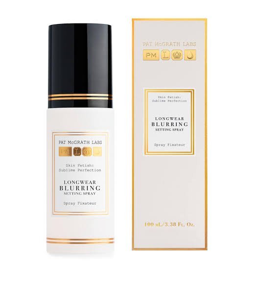 Front view of the luxury frosted 100ml bottle of Pat McGrath Labs Skin Fetish Blurring Setting Spray, featuring its signature minimal black typography and sophisticated gold accents, available on glamit.pk Pakistan.