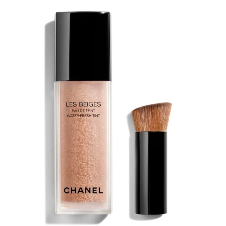 Chanel Les Beiges Water-Fresh Tint clear bottle showcasing the encapsulated pigment droplets inside, sitting elegantly next to its signature small black blending brush, available on glamit.pk Pakistan