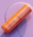 Front view of the luxury orange Tatcha Brightening Face Serum bottle with elegant gold accents, displayed on a clean reflective vanity backdrop, available on glamit.pk Pakistan.